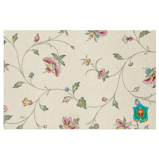 These handmade-to-order FeelGood Breakfast placemats feature a textured white background with a pastel floral pattern. Pink, yellow, and blue flowers are intertwined by green vines, with a vibrant emblem at the bottom right corner. Ideal as designer breakfast placemats.