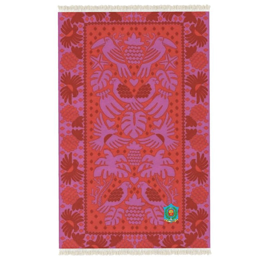 This handmade Rug boasts a vibrant red and purple textile with intricate woven designs of birds, hearts, and leaves. Its symmetrical pattern features stylized elements on a detailed backdrop, complemented by fringed edges for an artisanal touch.