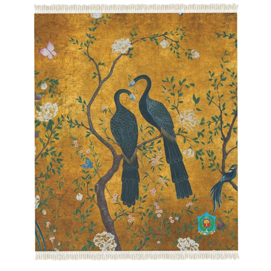 A handmade tapestry/rug depicting two blue peacocks on a branch among white flowers and greenery against a golden background, with a nearby butterfly. It features an anti-slip base for enhanced functionality.