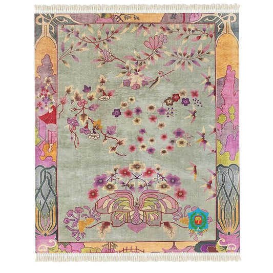 Handmade rug showcasing colorful, intricate patterns with floral and abstract designs, featuring vibrant pinks, yellows, and greens on a muted backdrop. It includes a fringe border and has an anti-slip base for safety.