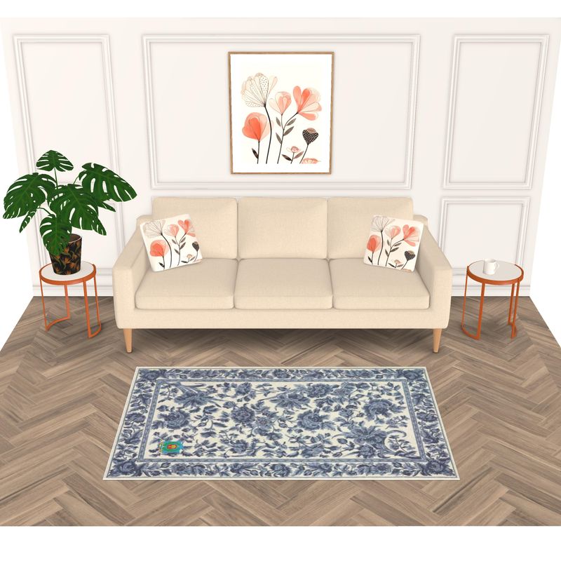 The living room showcases a beige sofa with floral pillows and framed floral art. A leafy plant is on the left, with round wooden side tables beside the sofa. An anti-slip designer rug in blue and white patterns beautifully ties the space together.
