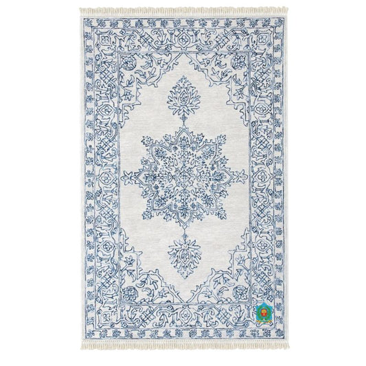 The heavyweight velvet rug features an intricate blue floral pattern on light gray, a symmetrical central medallion, ornate border, fringed ends, and an anti-slip base for safety.