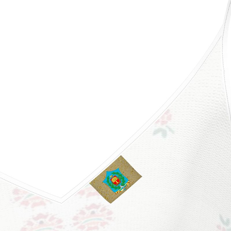 A close-up of the charming "Hello, World!" fabric reveals pink floral patterns with a small square patch. This designer slip dress showcases a blue star, red flower, and Cyrillic text on a golden background with black outlines, elegantly draping to form a V-shaped edge.