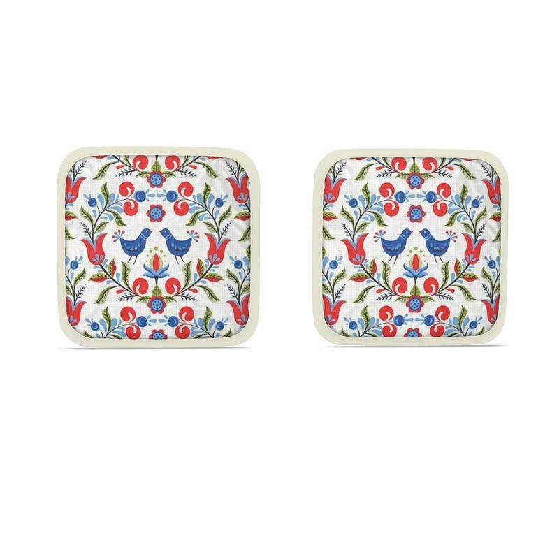 Lullaby of Birdland - Designer Pot Holder Set – Handmade, Heat-Resistant, Dual-Use with folk-art bird and floral pattern in red, blue, and green. Set of 2 with cream trim.