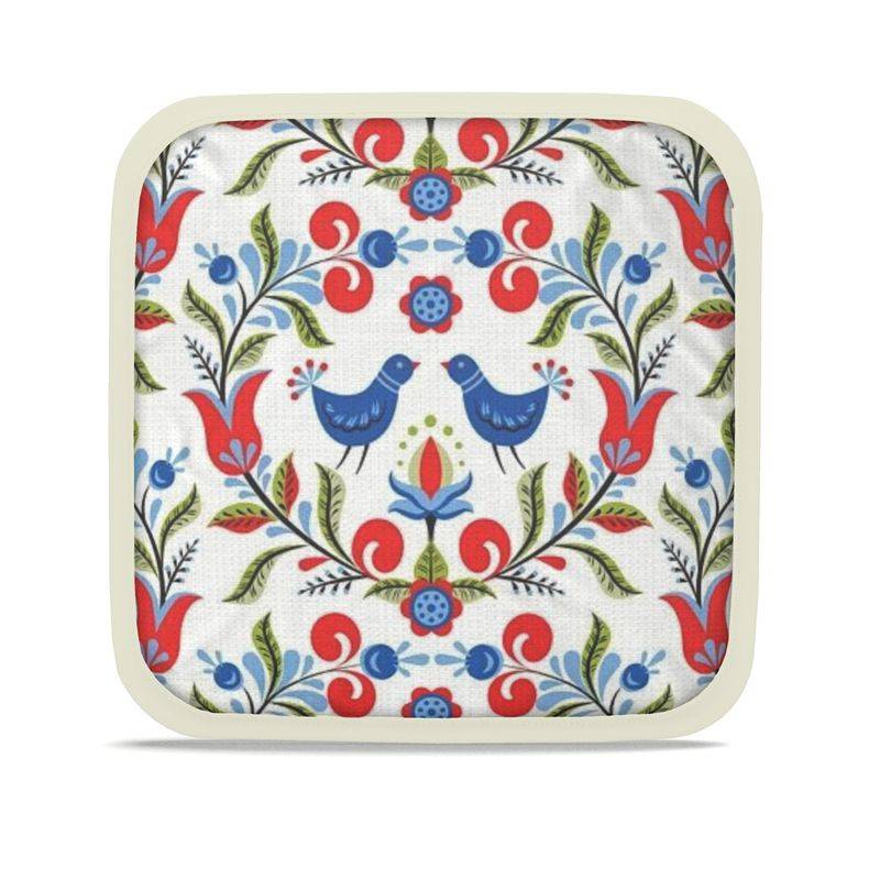 Lullaby of Birdland - Designer Pot Holder Set – Handmade, Heat-Resistant, Dual-Use with folk-art bird and floral pattern in red, blue, and green. Set of 2 with cream trim.