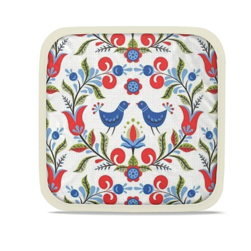 Lullaby of Birdland - Designer Pot Holder Set – Handmade, Heat-Resistant, Dual-Use with folk-art bird and floral pattern in red, blue, and green. Set of 2 with cream trim.